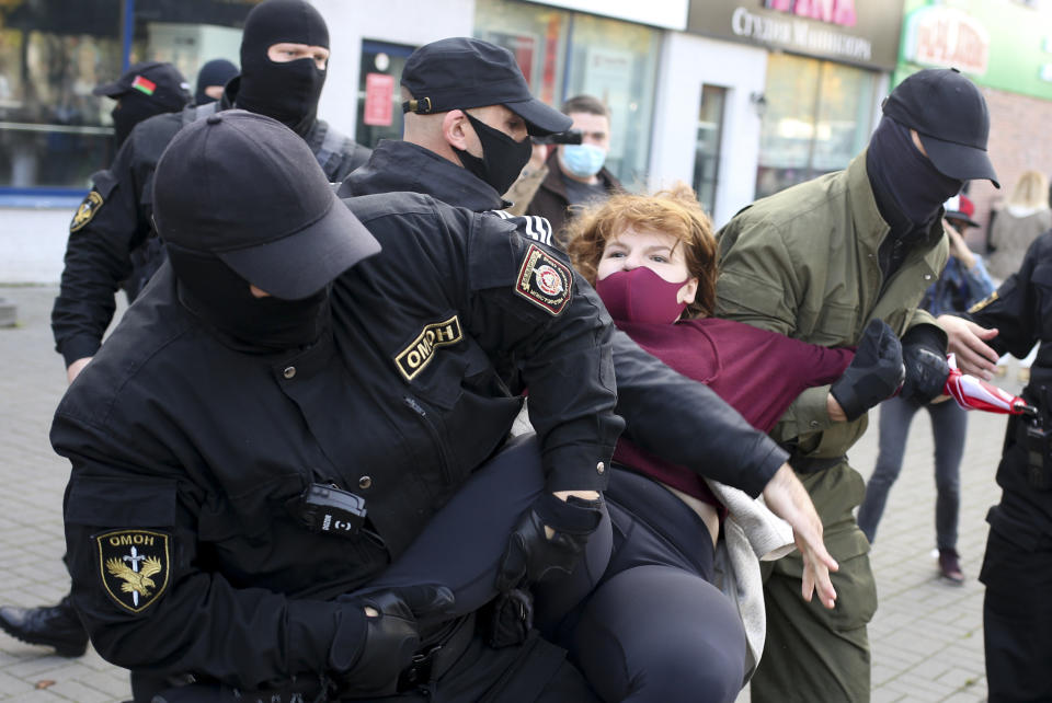 Police officers detain a woman during an opposition rally to protest the official presidential election results in Minsk, Belarus, Saturday, Sept. 19, 2020. Daily protests calling for the authoritarian president's resignation are now in their second month and opposition determination appears strong despite the detention of protest leaders. (AP Photo/TUT.by)