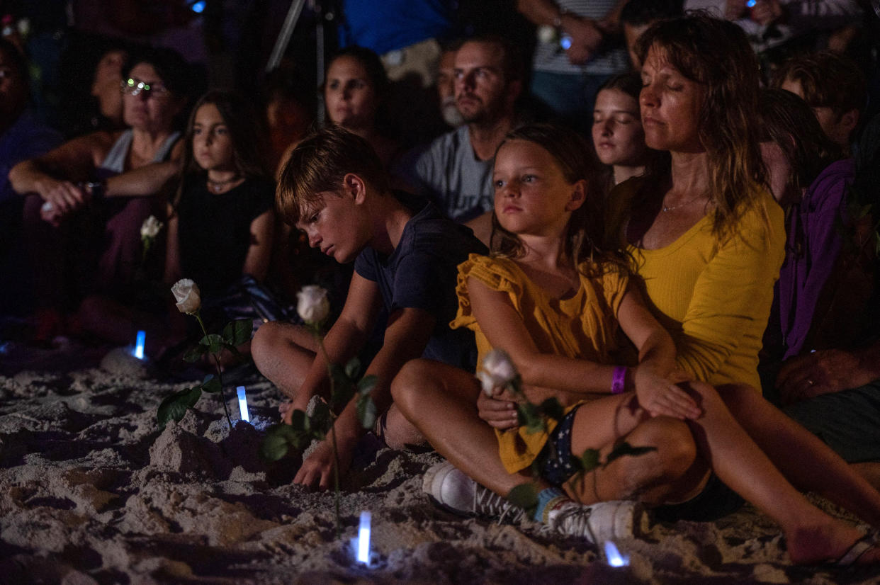 People attend a community vigil on the beach for those missing after the collapse of the Champlain Towers South condominium building in Surfside, Florida on June 28, 2021. (Giorgio Viera/AFP)