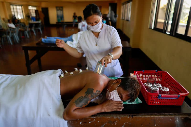 A volunteer performs ventosa or cupping therapy to a drug rehab patient to help ease withdrawals, at a community drug rehabilitation facility