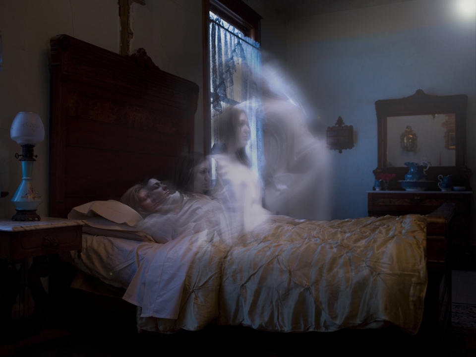 A ghost sitting up in bed