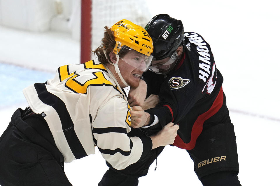 Ottawa Senators' Travis Hamonic, right, lands a punch against Pittsburgh Penguins' Brock McGinn (23) during the first period of an NHL hockey game in Pittsburgh, Friday, Jan. 20, 2023. (AP Photo/Gene J. Puskar)
