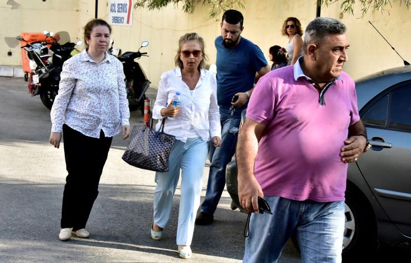 Turkish journalist Nazli Ilicak (C), also a well-known commentator and former parliamentarian, is escorted by a police officer (R) and her relatives (L and rear) after being detained and brought to a hospital for a medical check in Bodrum, Turkey, July 26, 2016. REUTERS/Kenan Gurbuz