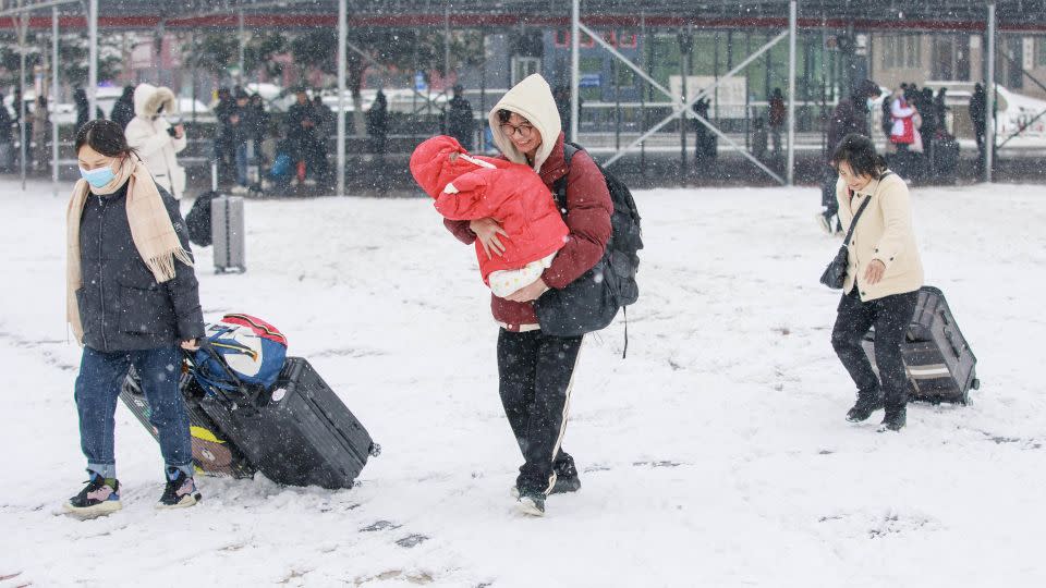 Travelers pull luggage through snow at Luohe Railway Station in Henan province on February 2. - Yang Guang/Visual China Group/Getty Images