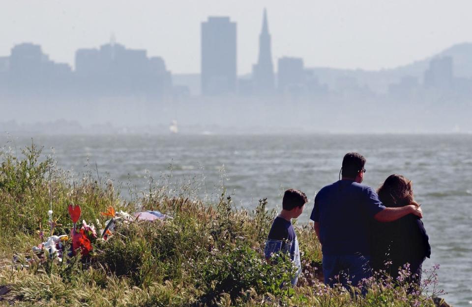 A family seen at a makeshift memorial where Laci Peterson’s body was found in April 2003 in Richmond, California (Getty Images)