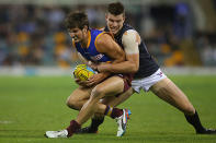 Sam Mayes of the Lions is tackled by Bryce Gibbs of the Blues and caught holding the ball.