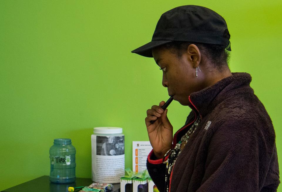 Jazmine Wilburn tests her new CDB vape pen at Wall’s Organic in Evansville, Ind., Thursday, June 2, 2022.