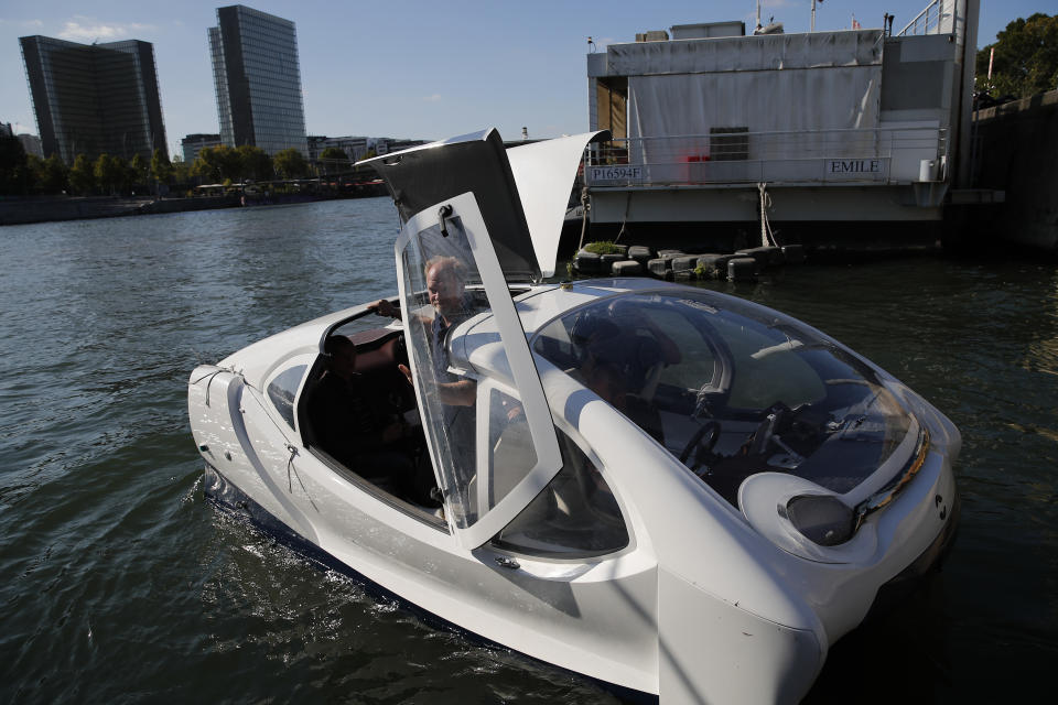 In this photo taken Tuesday Sept. 17, 2019, SeaBubbles co-founder Anders Bringdal stand aboard an hydrofoil boat SeaBubble on the Seine river in Paris. Paris is testing out a new form of travel - an eco-friendly bubble-shaped taxi that zips along the water, capable of whisking passengers up and down the Seine River. (AP Photo/Francois Mori)