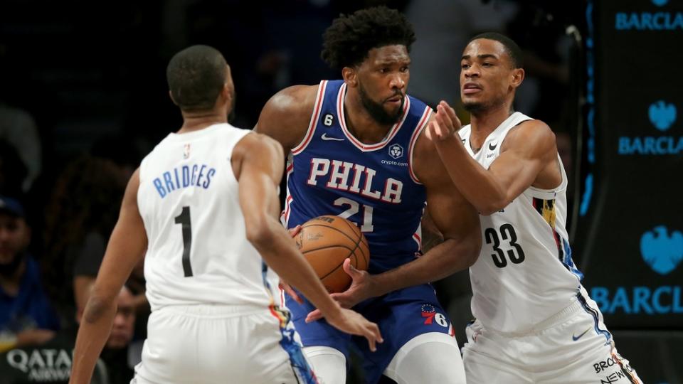 Feb 11, 2023; Brooklyn, New York, USA; Philadelphia 76ers center Joel Embiid (21) drives to the basket against Brooklyn Nets forward Mikal Bridges (1) and center Nic Claxton (33) during the third quarter at Barclays Center.