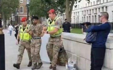 Lance Corporal Ahmed al Babati is led away by members of the Royal Military Police. Aug 24, 2020. 