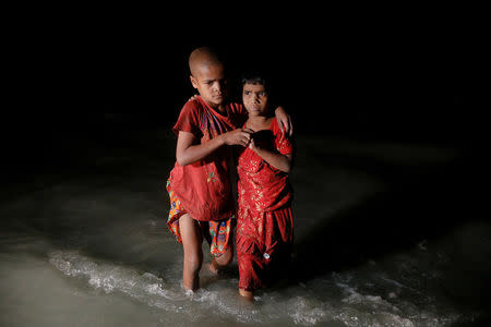 Rohingya refugee sisters, who just arrived under the cover of darkness by wooden boats from Myanmar, hug each other as they try to find their parents at Shah Porir Dwip, in Teknaf, near Cox's Bazar in Bangladesh. REUTERS/Damir Sagolj