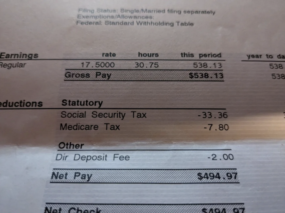 View of a paycheck showing gross pay of $538.13 with deductions for Social Security, Medicare, and direct deposit fee, leaving a net pay of $494.97