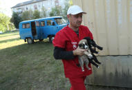 <p>Pavel “Pasho” Burkatsky, a professional dog catcher from Kiev, releases stray puppies that have been neutered and vaccinated inside the exclusion zone next to workers’ dormitories near the Chernobyl nuclear power plant on Aug. 18, 2017, in Chernobyl, Ukraine. Burkatsky was taking part in the Dogs of Chernobyl project launched by the Clean Futures Fund, a U.S.-based charity that pursues humanitarian projects at Chernobyl. (Photo: Sean Gallup/Getty Images) </p>