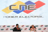 Venezuela's re-elected President Nicolas Maduro gestures next to the President of National Electoral Council (CNE), Tibisay Lucena, after receiving a certificate confirming him as winner of Sunday's election, in Caracas, Venezuela May 22, 2018. REUTERS/Marco Bello