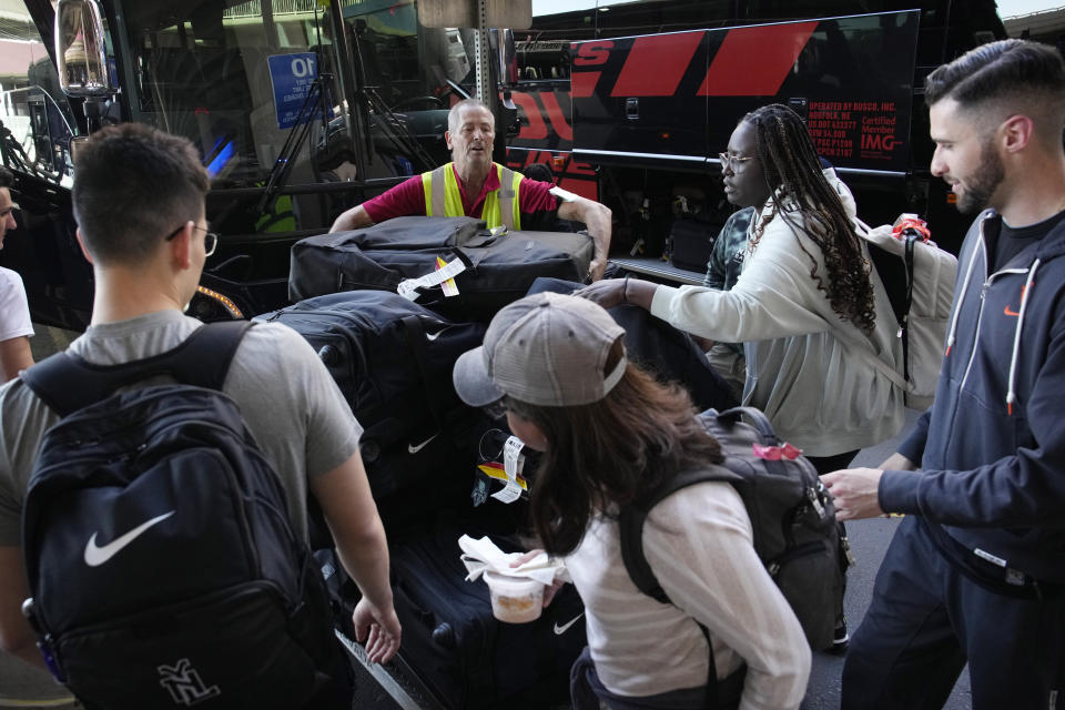 Baggage handlers and New York Liberty WNBA basketball team load bags onto buses at Harry Reid International Airport, Wednesday, June 28, 2023, in Las Vegas. (AP Photo/John Locher)