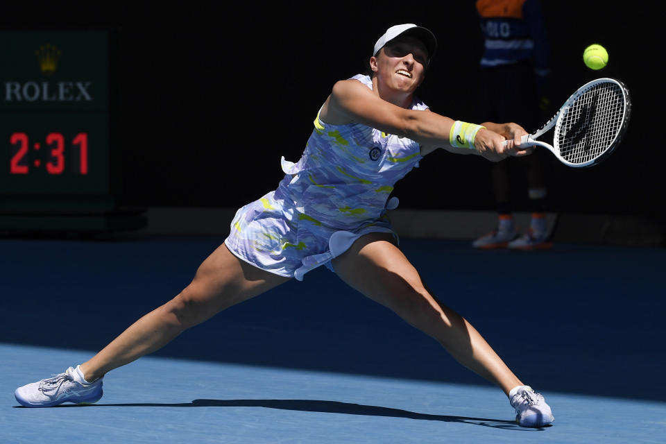 Iga Swiatek of Poland plays a backhand return to Kaia Kanepi of Estonia during their quarterfinal match at the Australian Open tennis championships in Melbourne, Australia, Wednesday, Jan. 26, 2022. (AP Photo/Andy Brownbill)