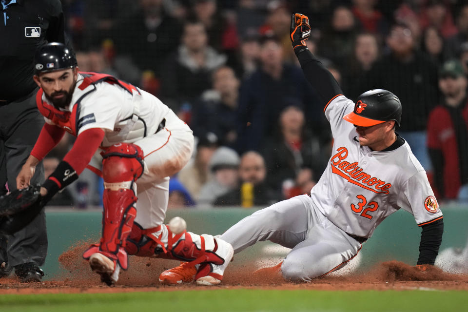 Baltimore Orioles' Ryan O'Hearn (32) scores on a bases loaded wild pitch as Boston Red Sox catcher Connor Wong, left, reaches for the ball during the seventh inning of a baseball game, Wednesday, April 10, 2024, in Boston. (AP Photo/Charles Krupa)