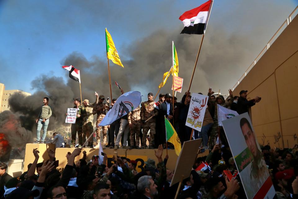 Protesters burn property in front of the U.S. embassy compound, in Baghdad, Iraq, Tuesday, Dec. 31, 2019. Dozens of angry Iraqi Shiite militia supporters broke into the U.S. Embassy compound in Baghdad on Tuesday after smashing a main door and setting fire to a reception area, prompting tear gas and sounds of gunfire. (AP Photo/Khalid Mohammed)