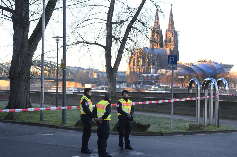 Employees of the public order office block a road close to the Cologne Cathedral in Cologne, Germany, Tuesday, Jan. 21, 2020. A train station, an opera house and a TV station in the western Germany city of Cologne are evacuated on Tuesday as experts prepare to defuse an American 500-kilogram (1,100-pound) bomb from World War II. (Roberto Pfeil/dpa via AP)