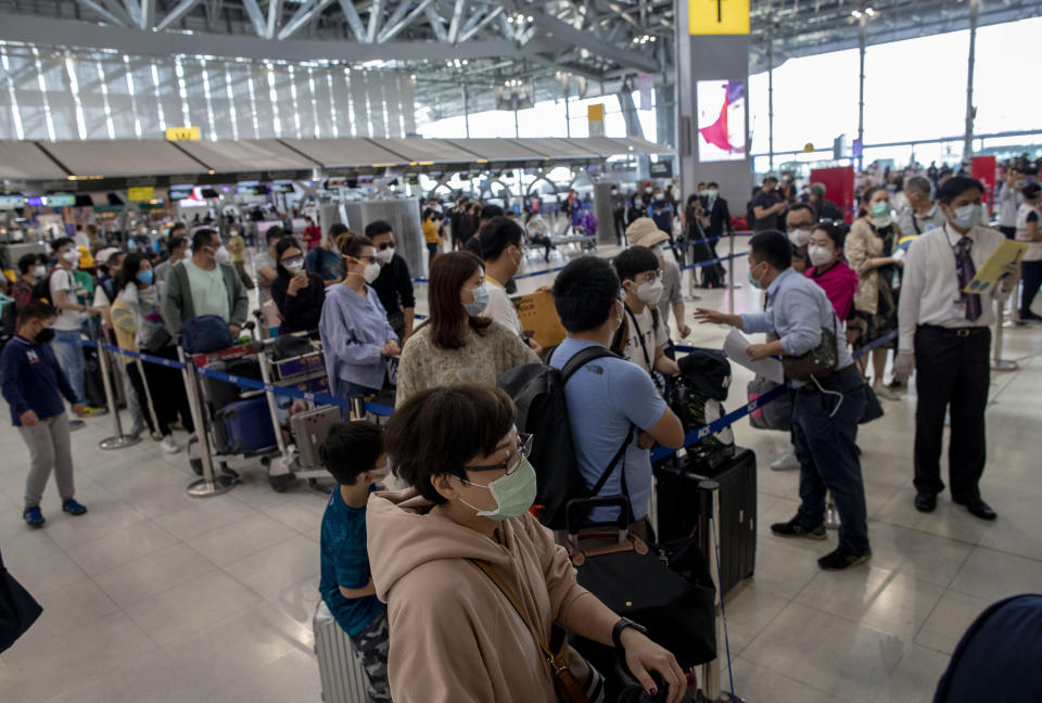 Tourists from Wuhan, China, stand in a line for a charter flight back to Wuhan at the Suvarnabhumi airport, Bangkok, Thailand, Friday, Jan. 31, 2020. A group of Chinese tourists who have been trapped in Thailand since Wuhan was locked down due to an outbreak of new virus returned to China on Friday. (AP Photo/Gemunu Amarasinghe)