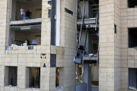 People stand in a damaged building near the scene of Tuesday's explosion that hit the seaport of Beirut, Lebanon, Sunday, Aug. 9, 2020. Public fury over the massive explosion in Beirut took a new turn Saturday night as protesters stormed government institutions and clashed for hours with security forces, who responded with heavy volleys of tear gas and rubber bullets. (AP Photo/Thibault Camus)