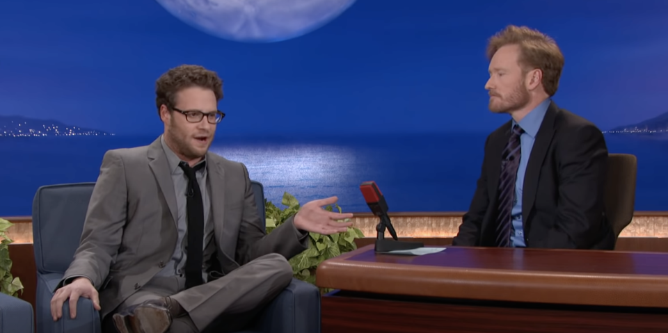 Seth sitting with Conan O'Brien on the late show