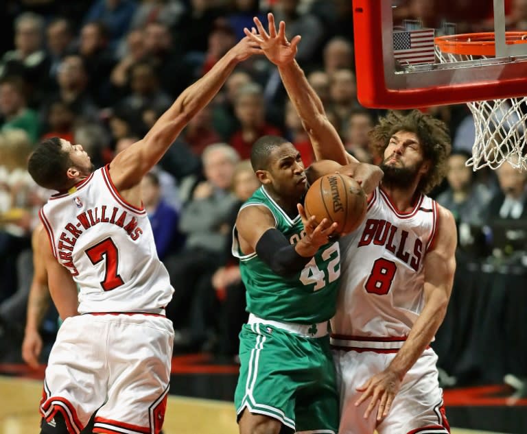 Al Horford of the Boston Celtics puts up a shot between Michael Carter-Williams (L) and Robin Lopez of the Chicago Bulls during Game Three of the Eastern Conference Quarterfinals