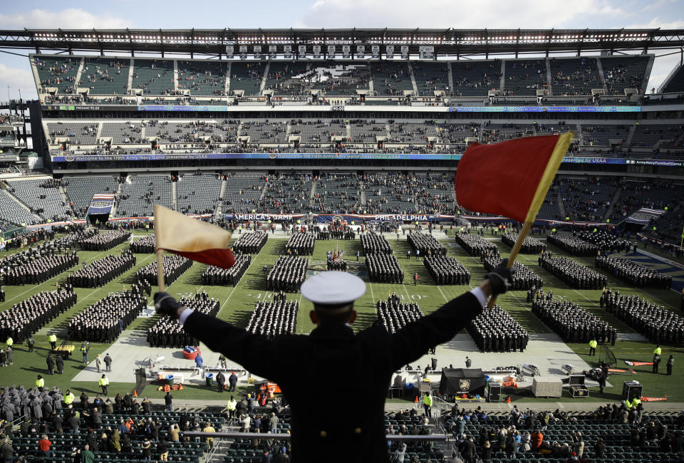 FILE - In this Dec. 8, 2018, file photo, Navy Midshipman Frey Pankratz singles his classmates as they march onto the field ahead of an NCAA college football against the Army in Philadelphia. The 120th Army-Navy game is set for Saturday in Philadelphia. Navy leads the series 60-52-7. (AP Photo/Matt Rourke, File)