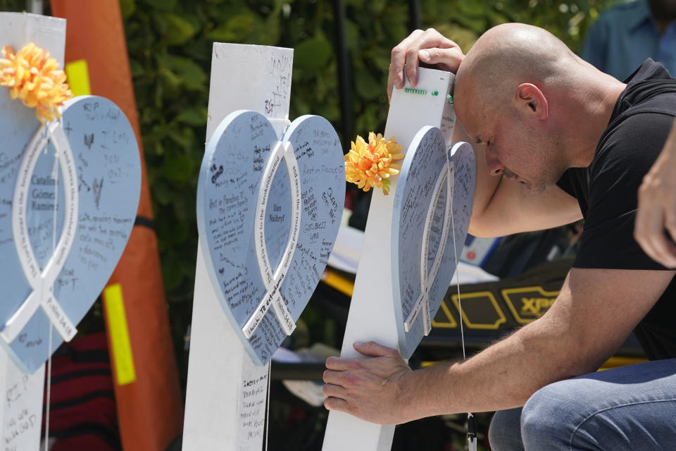 Lazaro Carnero mourns for his best friend Edgar Gonzalez, during a remembrance event at the site of the Champlain Towers South building collapse, Friday, June 24, 2022, in Surfside, Fla. Friday marks the anniversary of the oceanfront condo building collapse that killed 98 people in Surfside, Florida. The 12-story tower came down with a thunderous roar and left a giant pile of rubble in one of the deadliest collapses in U.S. history. (AP Photo/Wilfredo Lee)