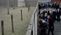 Under grey skies, German leaders and those from Poland, Hungary, Czech Republic and Slovakia put roses through cracks in part of the Wall that still stands