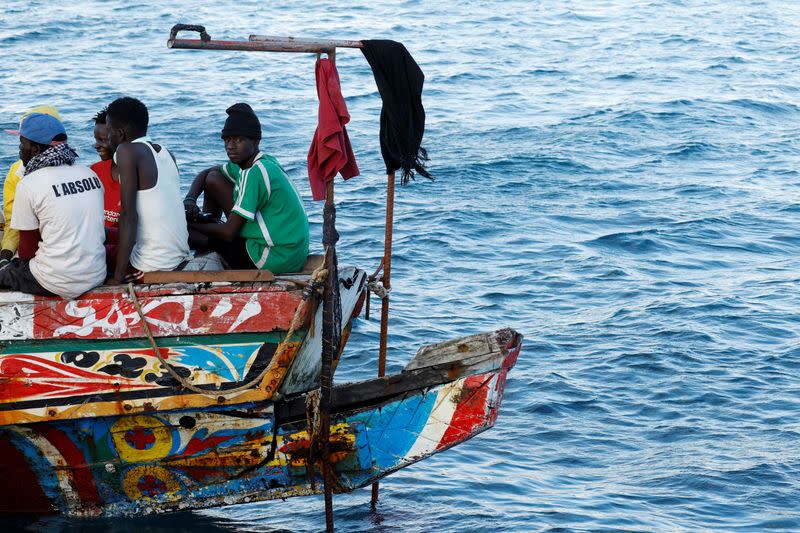 Group of migrants in a wooden boat are towed by a Spanish coast guard vessel to the port of Arguineguin