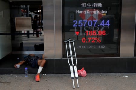 A man lies down next to an HSBC bank branch in Kowloon district, Hong Kong