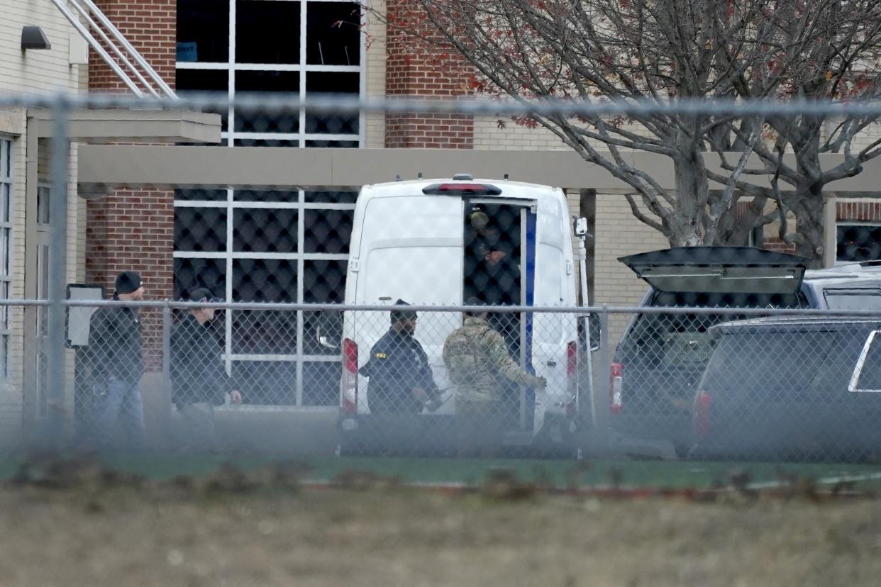 Law enforcement officials gather at Colleyville Elementary School near the Congregation Beth Israel synagogue on Saturday, Jan. 15, 2022 in Colleyville, Texas. Authorities said a man took hostages Saturday during services at the synagogue where the suspect could be heard ranting in a livestream and demanding the release of a Pakistani neuroscientist who was convicted of trying to kill U.S. Army officers in Afghanistan. (AP Photo/Tony Gutierrez)