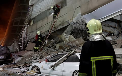 A fireman works at a collapses building after earthquake hit Hualien - Credit: Tyrone Siu/Reuters