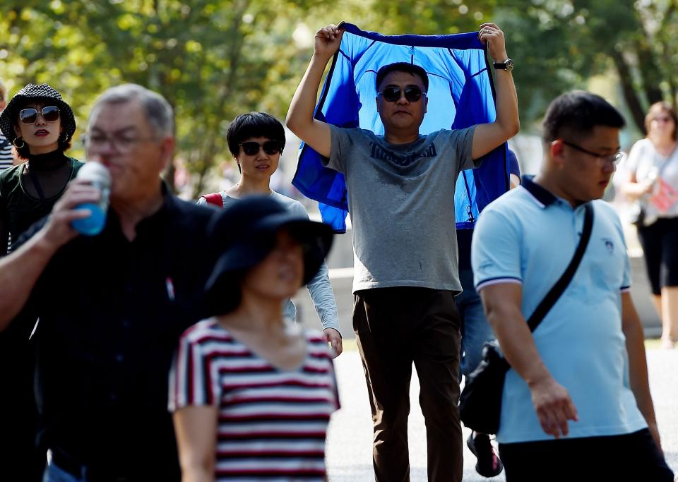 A tourist visiting the Lincoln Memorial shields himself from the sun as temperatures are expected to soar into mid-90s, on October 2, 2019 in Washington, DC. (Photo: OLIVIER DOULIERY via Getty Images)