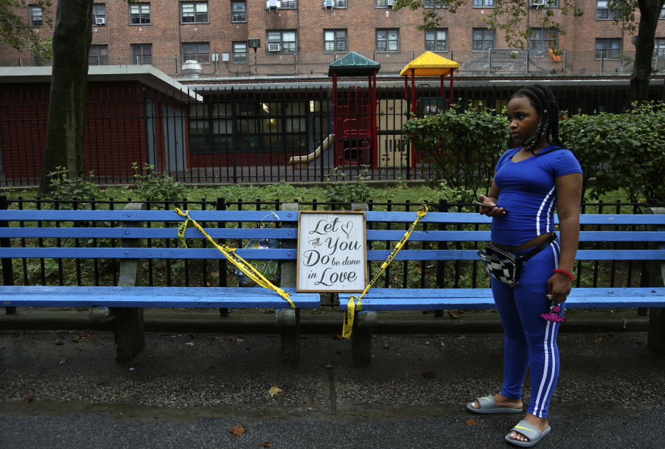 Maddison Washington, 11, stands beside a park bench where three young men were shot at her family's housing development in the Brooklyn borough of New York, on Thursday, Aug. 13, 2020. Washington's mother sent her and her twin brother to stay with their father in North Carolina for part of the summer while she saved money, food stamps and Pandemic Electronic Benefit Transfers (PEBT) to ensure the family had enough food when the siblings returned. (AP Photo/Jessie Wardarski)