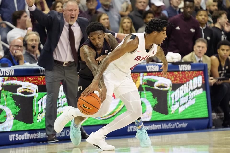 Texas A&M guard Wade Taylor IV, left center, steals the ball from SMU guard B.J. Edwards as Texas A&M head coach Buzz Williams looks on during the first half of an NCAA college basketball game in Dallas, Tuesday, Nov. 14, 2023. (AP Photo/LM Otero)