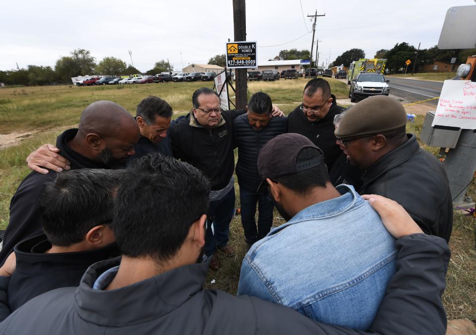 <p>A group of 12 pastors from local churches, pray beside a memorial service for victims of the mass shooting that killed 26 people in Sutherland Springs, Texas on Nov. 8, 2017. (Photo: Mark Ralston/AFP/Getty Images) </p>