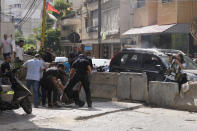 Supporters of a Shiite group allied with Hezbollah help an injured comrade during armed clashes that erupted during a protest in the southern Beirut suburb of Dahiyeh, Lebanon, Thursday, Oct. 14, 2021. It was not immediately clear what triggered the gunfire, but tensions were high along a former civil war front-line between Muslim Shiite and Christian areas. (AP Photo/Hassan Ammar)