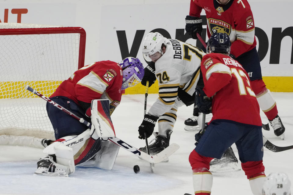 Boston Bruins left wing Jake DeBrusk (74) hits the puck between the legs of Florida Panthers goaltender Sergei Bobrovsky (72) to score a goal during the second period of an NHL hockey game, Wednesday, Nov. 22, 2023, in Sunrise, Fla. (AP Photo/Marta Lavandier)