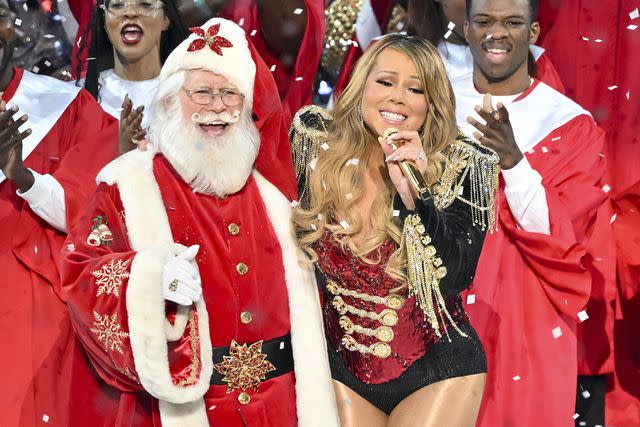 <p>James Devaney/CBS via Getty Images</p> Mariah Carey sings with Santa Claus on her concert special