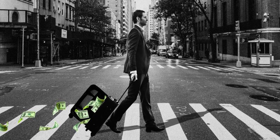 A man crossing the street with money falling out of his suitcase