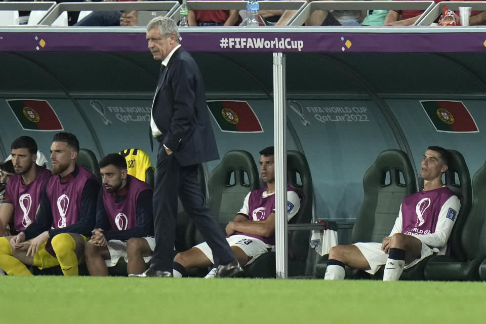 Portugal's Cristiano Ronaldo, right, sits on the bench during the World Cup group H soccer match between South Korea and Portugal, at the Education City Stadium in Al Rayyan , Qatar, Friday, Dec. 2, 2022. (AP Photo/Hassan Ammar)