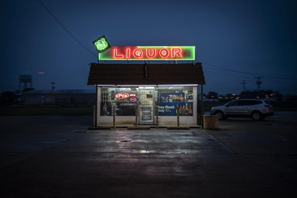 A liquor store is illuminated against the dusk sky in Cleveland, Miss., Friday, Oct. 9, 2020. (AP Photo/Wong Maye-E)