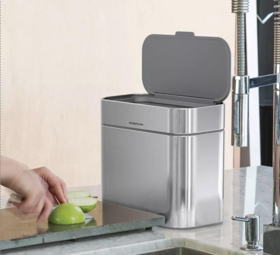 a stainless steel compost bin on a kitchen counter