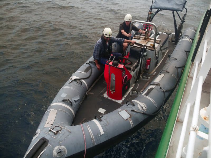 Arctic Sunrise ship crew members are seen on a rigid inflatable boat as it is lowered into the Indian Ocean at the Saya de Malha Bank