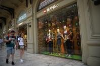 A couple walk past the Jeans'a boutique opened instead of Levi's (Levi Strauss & Co) American boutique closed due to sanctions in the GUM department store in Moscow, Russia, Tuesday, Aug. 9, 2022. Russians are snapping up Western fashion and furniture this week as H&M and IKEA sell off the last of their inventory in Russia, moving forward with their exit from the country after it sent troops into Ukraine. Sweden-based H&M and Netherlands-based IKEA had paused sales in Russia after the military operation began and are now looking to unload their stocks of clothing and furnishings as they wind down operations there. (AP Photo/Alexander Zemlianichenko)