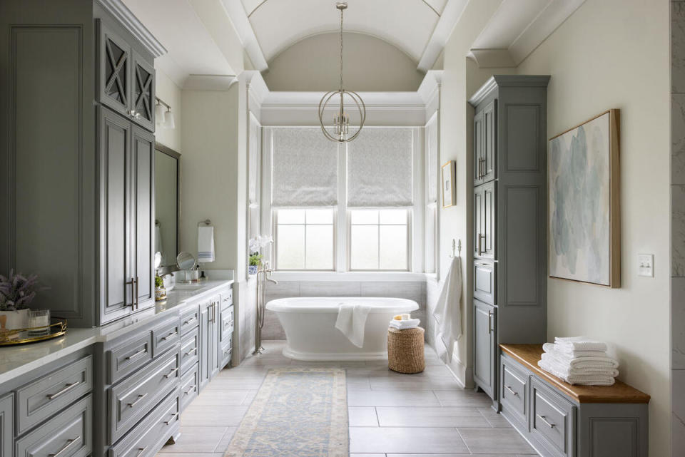In a light-filled bathroom by designer Kristina Petit, cabinets in a rich blue-green hue act almost as a neutral, complementing the warm beige walls. Petit cites Canva, Planoly and Design Files as the three platforms that keep her firm running.