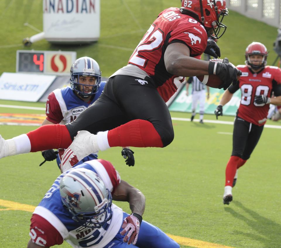 Calgary Stampeders' Nik Lewis, top, leaps over Montreal Alouettes' Michael Carter and into the end zone for a touchdown during second half CFL acton in Calgary on Friday July 1st, 2011. CFL PHOTO-Larry MacDougal