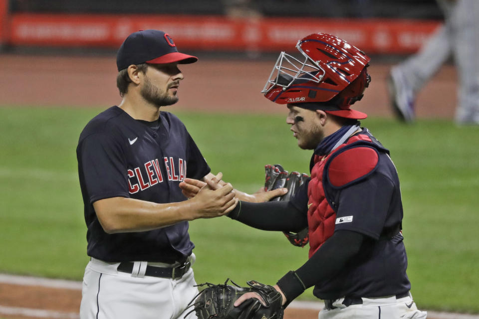 Cleveland Indians relief pitcher Brad Hand, left, is congratulated by catcher Roberto Perez after they defeated the Kansas City Royals in a baseball game, Friday, July 24, 2020, in Cleveland. (AP Photo/Tony Dejak)