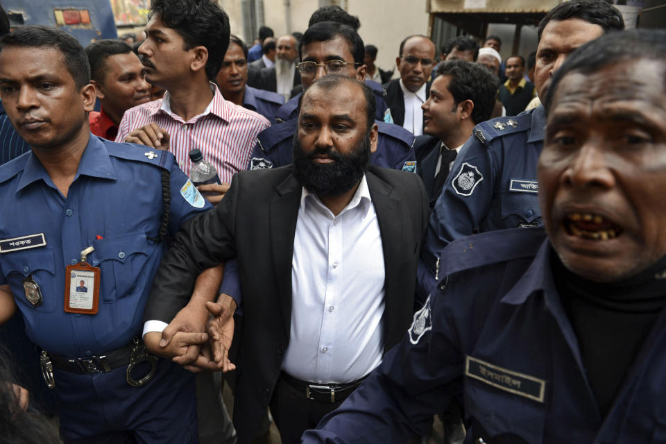 One of the two owners of Tazreen Fashions Ltd., Delwar Hossain, center, is escorted by security personnel to a court in Dhaka, Bangladesh, Sunday, Feb. 9, 2014. Two owners of a Bangladesh garment factory where 112 workers died in a fire two years ago surrendered on Sunday and sought bail after they were charged with homicide. (AP Photo)